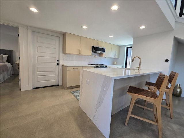 5305 Grover Ave Unit 2, Austin, TX 78756 - kitchen featuring stainless steel microwave, light countertops, recessed lighting, finished concrete flooring, and a breakfast bar area