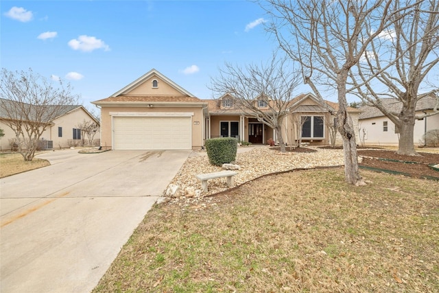 ranch-style house featuring a garage, driveway, and stucco siding