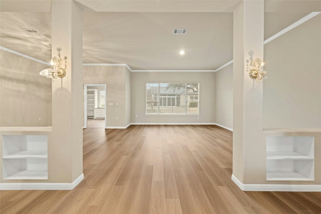 122 Durango Trl, Georgetown, TX 78633 - unfurnished living room with a chandelier, built in shelves, ornamental molding, baseboards, and wood finished floors