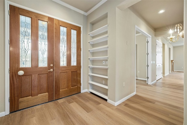 foyer entrance featuring a chandelier, baseboards, and light wood-style floors