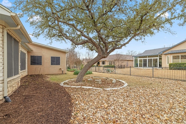 view of yard with a sunroom and fence