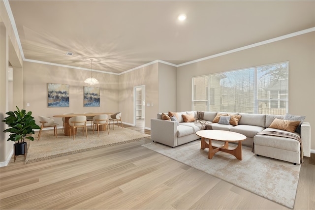 living room with baseboards, ornamental molding, and wood finished floors