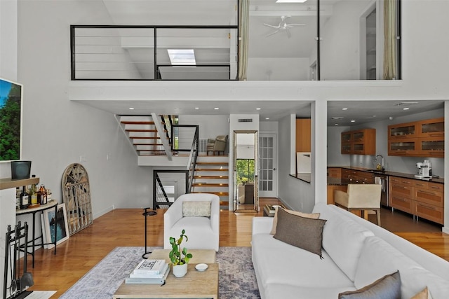 living room featuring a skylight, stairway, and wood finished floors