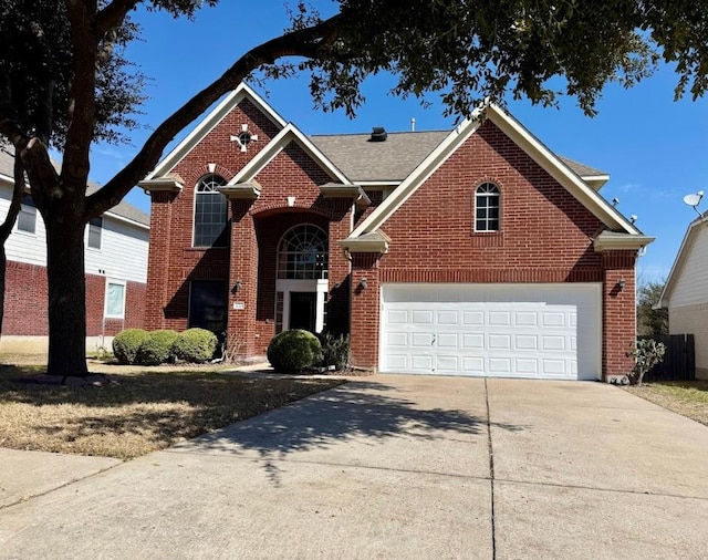 traditional-style home featuring brick siding, driveway, and an attached garage