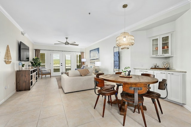 dining space featuring light tile patterned floors, ceiling fan, baseboards, ornamental molding, and french doors