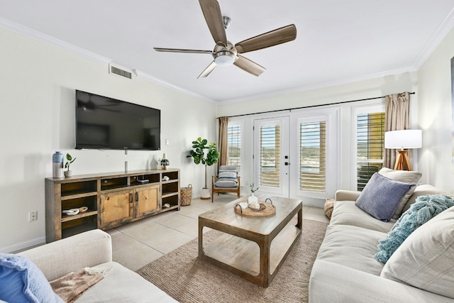 living room featuring light tile patterned flooring, a ceiling fan, baseboards, visible vents, and crown molding