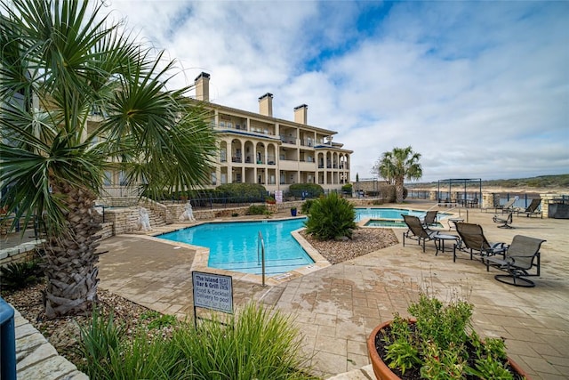 pool with a patio area and fence