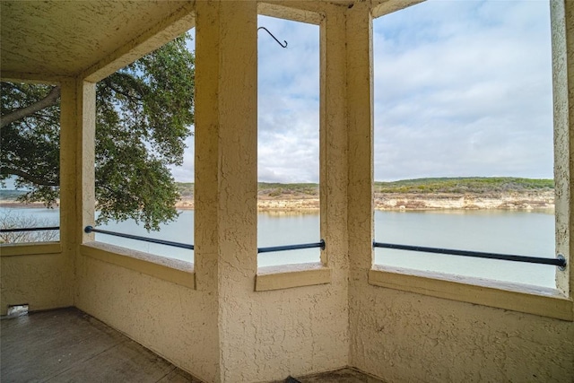 unfurnished sunroom featuring a water view