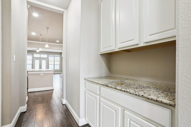 bar featuring ceiling fan, dark wood-style flooring, and baseboards