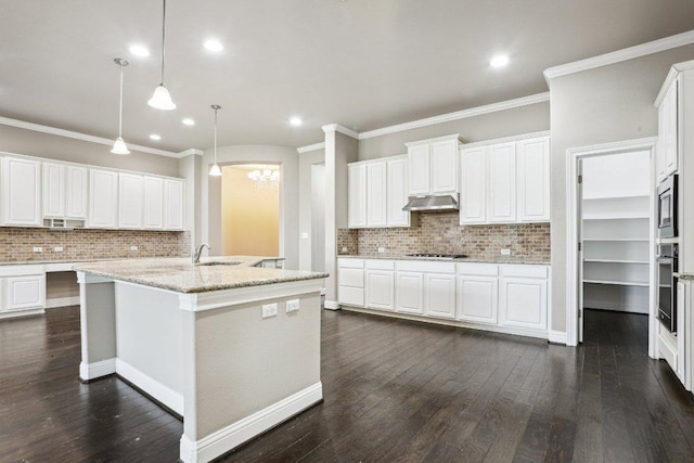 kitchen with wall oven, stainless steel microwave, dark wood-style flooring, stovetop, and under cabinet range hood