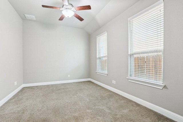 carpeted spare room with a ceiling fan, visible vents, and baseboards