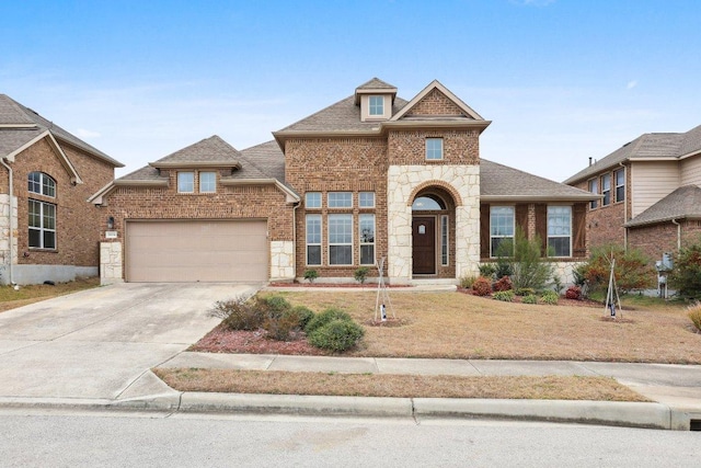 view of front of house featuring a shingled roof, concrete driveway, stone siding, an attached garage, and brick siding