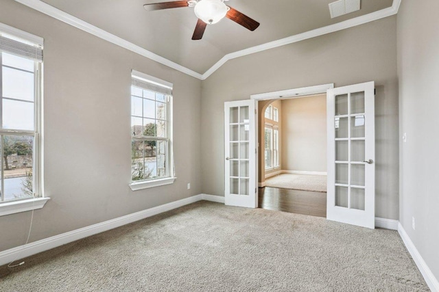 empty room featuring french doors, crown molding, lofted ceiling, visible vents, and carpet flooring