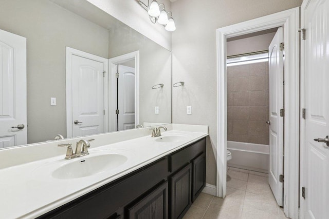 bathroom with double vanity, tile patterned flooring, a sink, and toilet