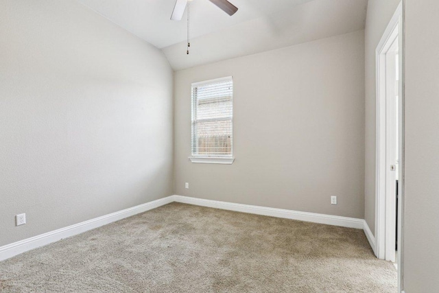 spare room featuring carpet flooring, vaulted ceiling, baseboards, and ceiling fan