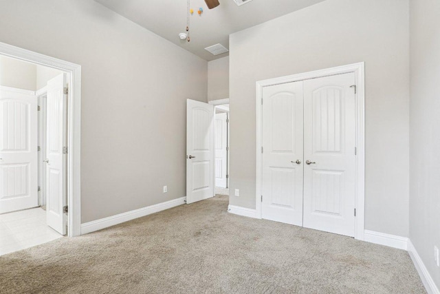 unfurnished bedroom with carpet, a closet, connected bathroom, and baseboards