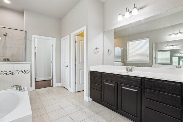 bathroom featuring vanity, baseboards, a bath, tile patterned floors, and a stall shower