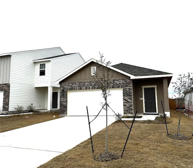 view of front of property featuring a garage, concrete driveway, and brick siding