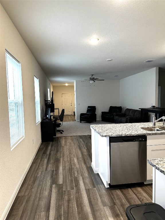 kitchen with dark wood-style floors, visible vents, white cabinets, a sink, and dishwasher