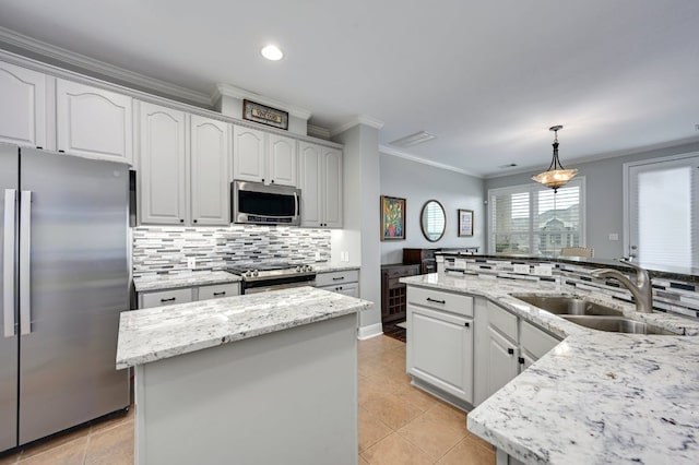 kitchen featuring a center island, a sink, stainless steel appliances, crown molding, and backsplash