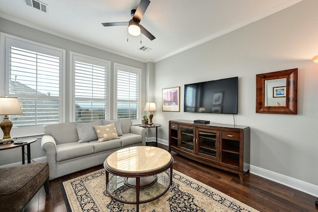 living area with a ceiling fan, visible vents, dark wood-type flooring, and ornamental molding