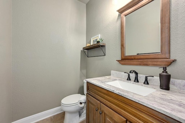 bathroom featuring toilet, tile patterned flooring, vanity, and baseboards