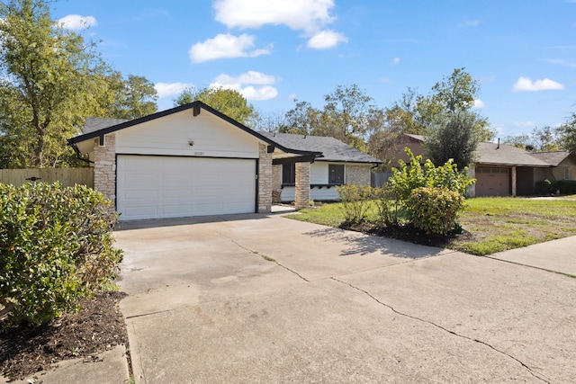 10001 Woodglen Dr, Austin, TX 78753 - ranch-style house featuring an attached garage, driveway, and stone siding