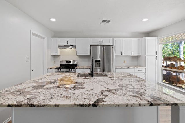 10001 Woodglen Dr, Austin, TX 78753 - kitchen with stainless steel appliances, under cabinet range hood, a large island with sink, white cabinetry, and recessed lighting