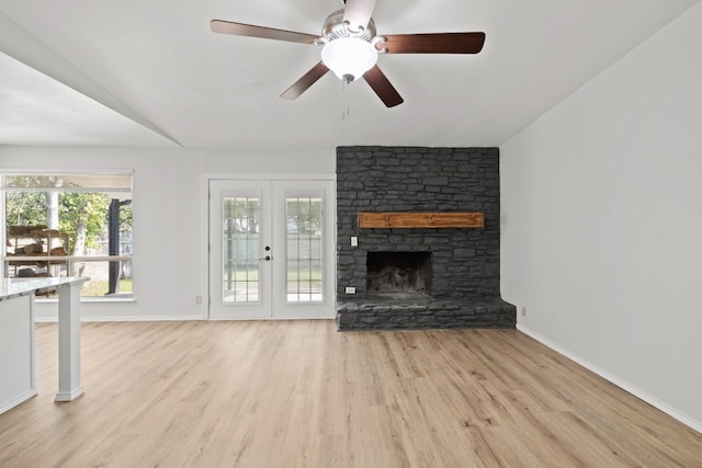 10001 Woodglen Dr, Austin, TX 78753 - unfurnished living room featuring wood finished floors, baseboards, a stone fireplace, and ceiling fan