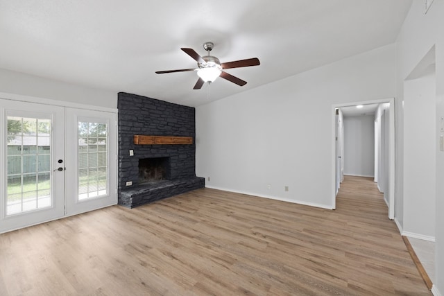 10001 Woodglen Dr, Austin, TX 78753 - unfurnished living room with french doors, ceiling fan, light wood-style flooring, and a stone fireplace