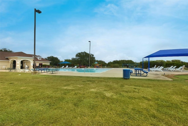 pool featuring a patio area and a lawn