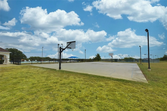 view of sport court with community basketball court, a yard, and fence