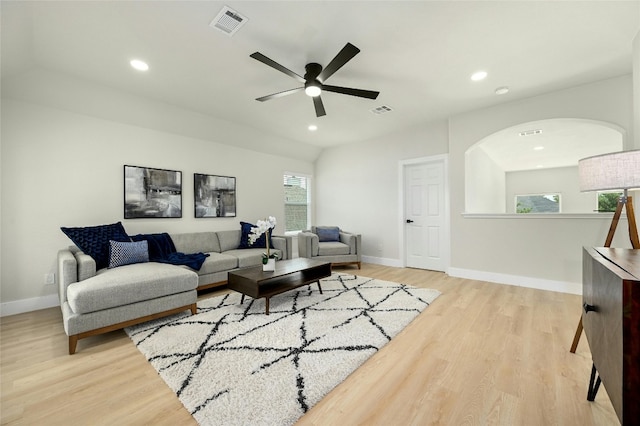 living room with light wood-style floors, visible vents, and baseboards