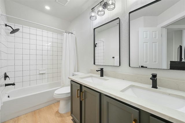 bathroom with visible vents, a sink, shower / bathtub combination with curtain, and wood finished floors