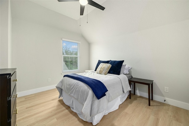 bedroom featuring vaulted ceiling, light wood-type flooring, a ceiling fan, and baseboards