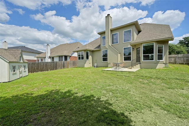 rear view of house with a yard, a patio area, a shed, a fenced backyard, and an outdoor structure