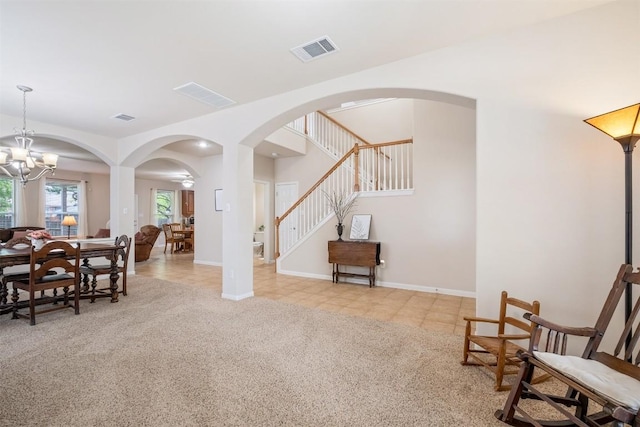 interior space with arched walkways, visible vents, a notable chandelier, and stairway