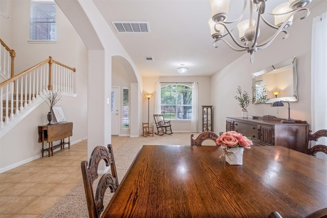 dining area featuring arched walkways, stairway, a chandelier, and visible vents