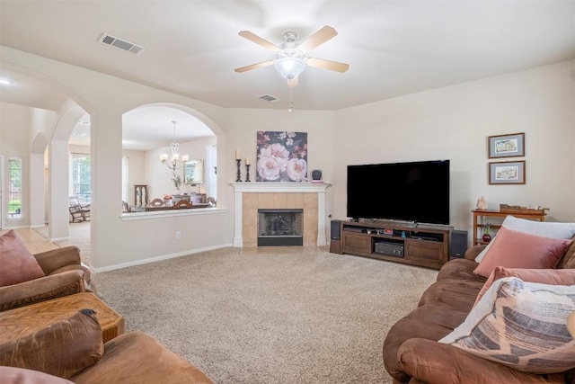 living room with a fireplace, visible vents, and light colored carpet