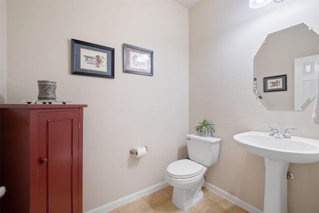 half bathroom featuring baseboards, toilet, and tile patterned floors