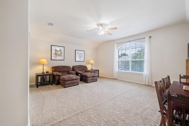 living area featuring baseboards, visible vents, a ceiling fan, lofted ceiling, and carpet flooring