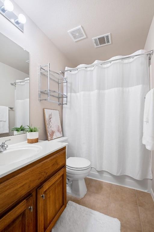 full bathroom with visible vents, vanity, toilet, and tile patterned floors