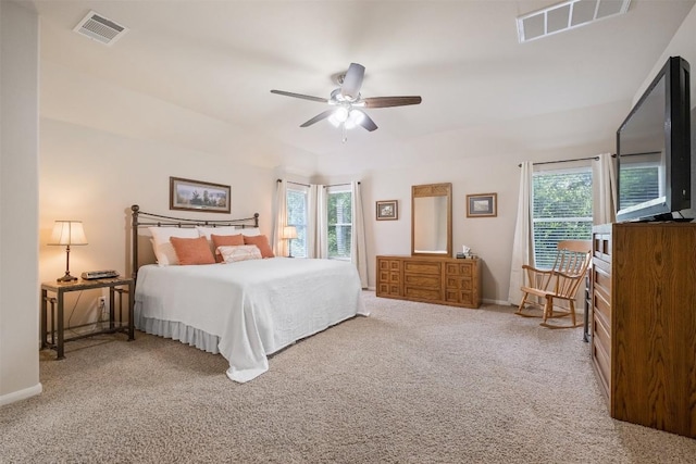 carpeted bedroom with baseboards, multiple windows, and visible vents