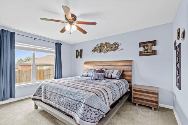 carpeted bedroom with ceiling fan and baseboards