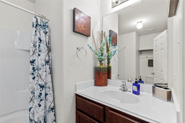 full bathroom featuring visible vents, shower / bath combo with shower curtain, and vanity