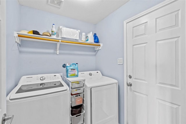 clothes washing area with laundry area, visible vents, and independent washer and dryer