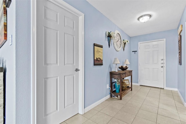 foyer entrance featuring baseboards and light tile patterned floors