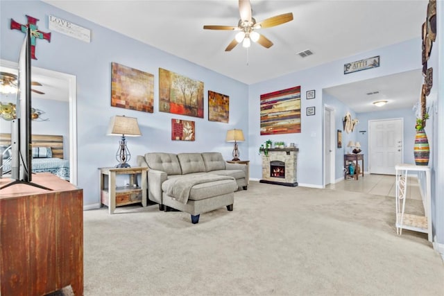 living area with baseboards, visible vents, a ceiling fan, carpet floors, and a fireplace