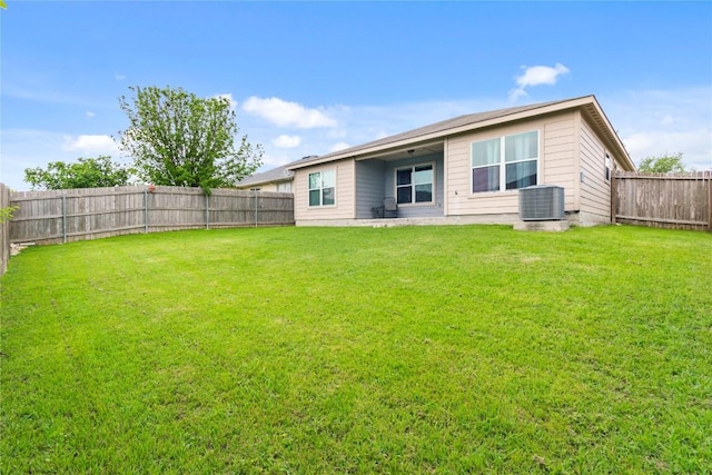 back of property with a yard, central AC, and a fenced backyard