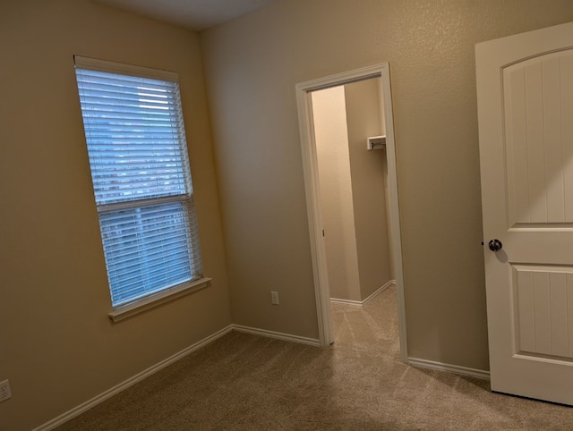 unfurnished bedroom with carpet and baseboards